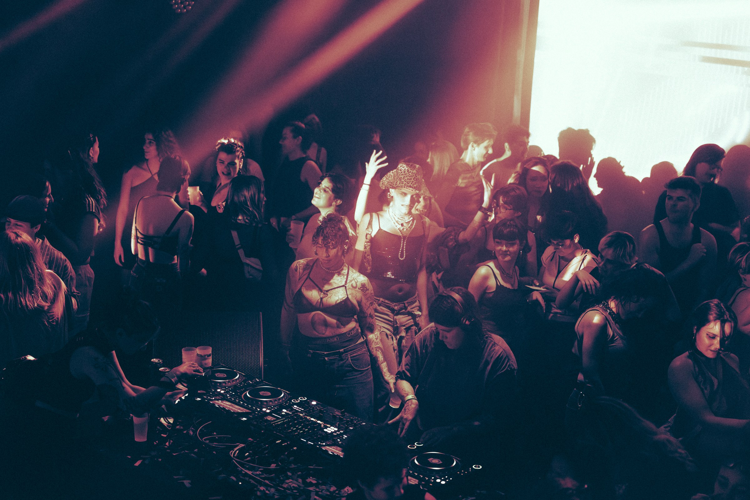 DJ booth et foule dansante, lumi&egrave;re rose