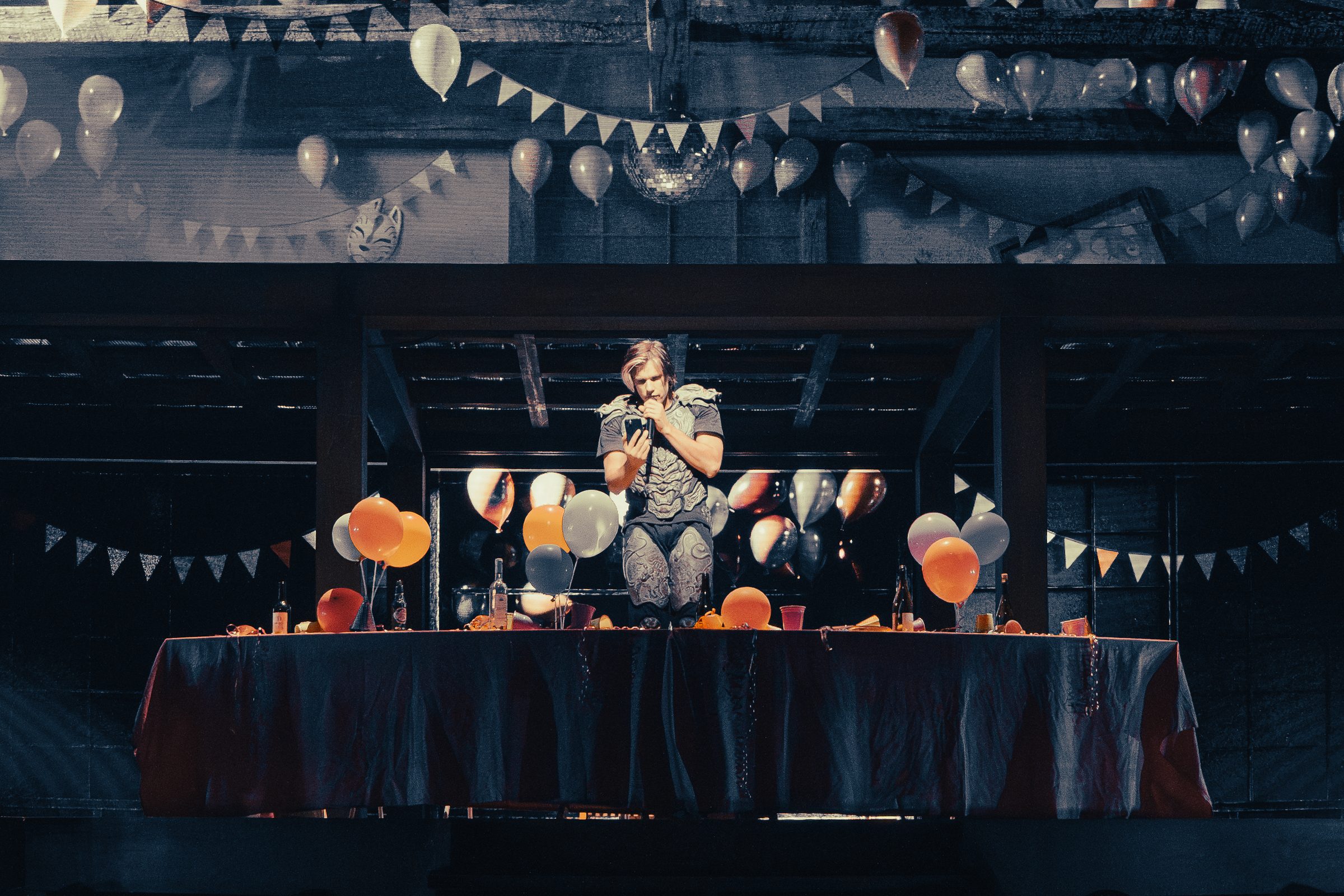 Orelsan &eacute;clair&eacute; au centre d'un d&eacute;cor de f&ecirc;te, ballons et guirlandes