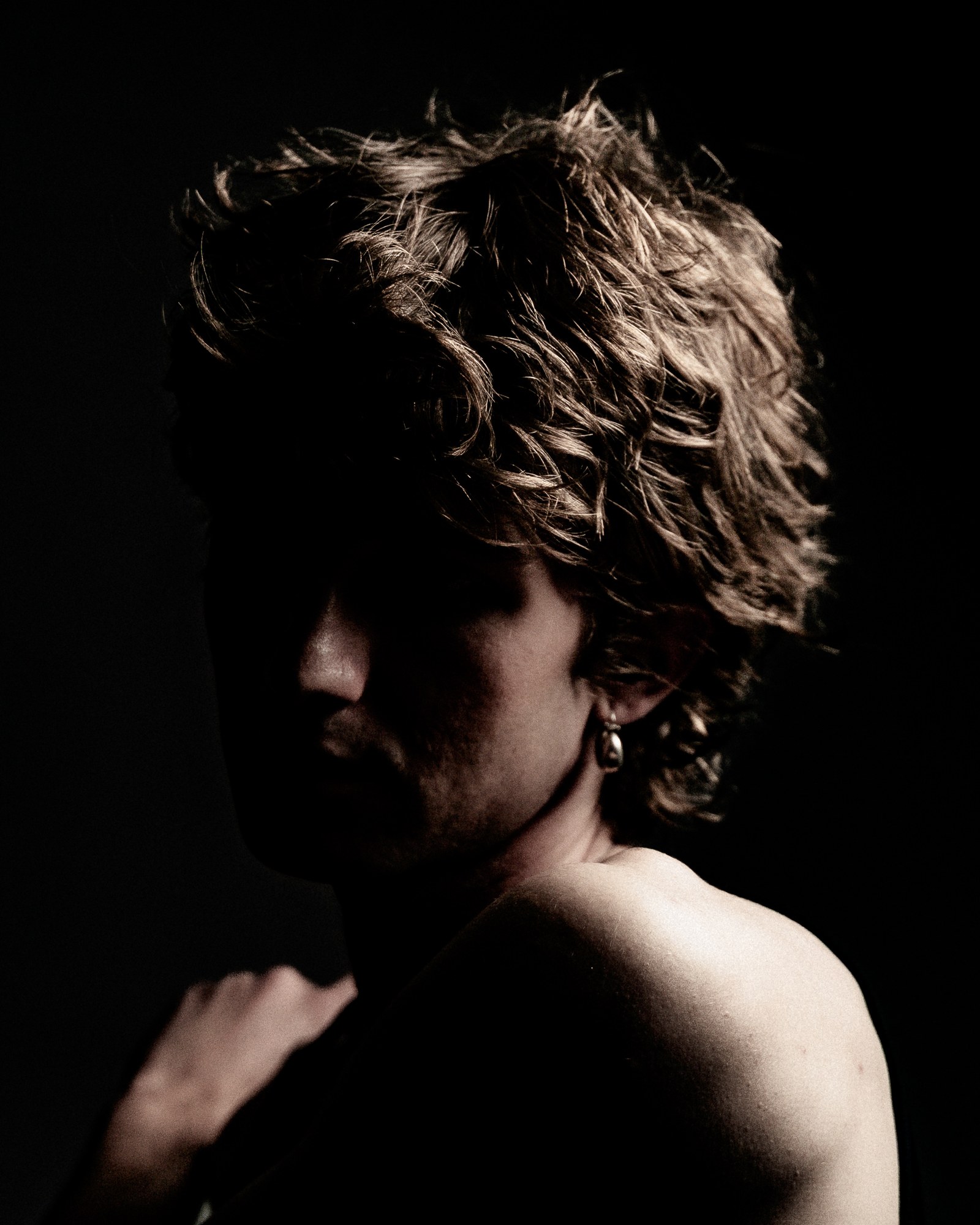 Portrait au clair-obscur, cheveux boucl&eacute;s, &eacute;paules nues