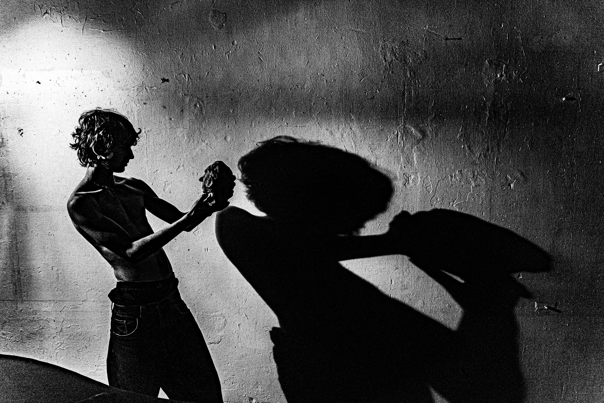 Deux silhouettes et jeu d'ombres sur un mur, noir et blanc