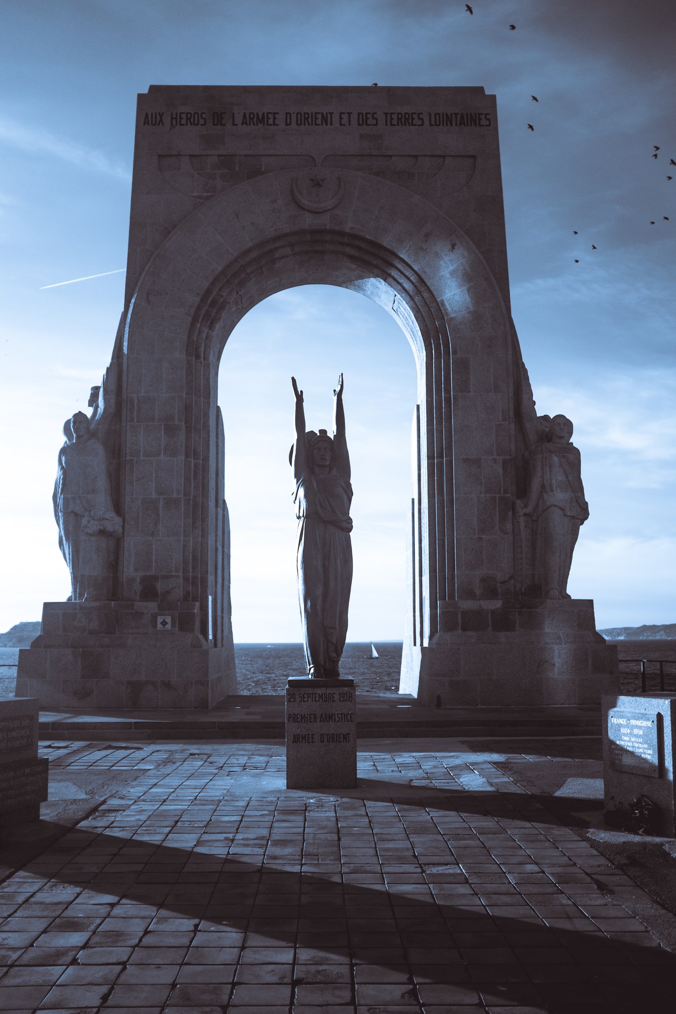 Arc monumental et statue, ciel dramatique