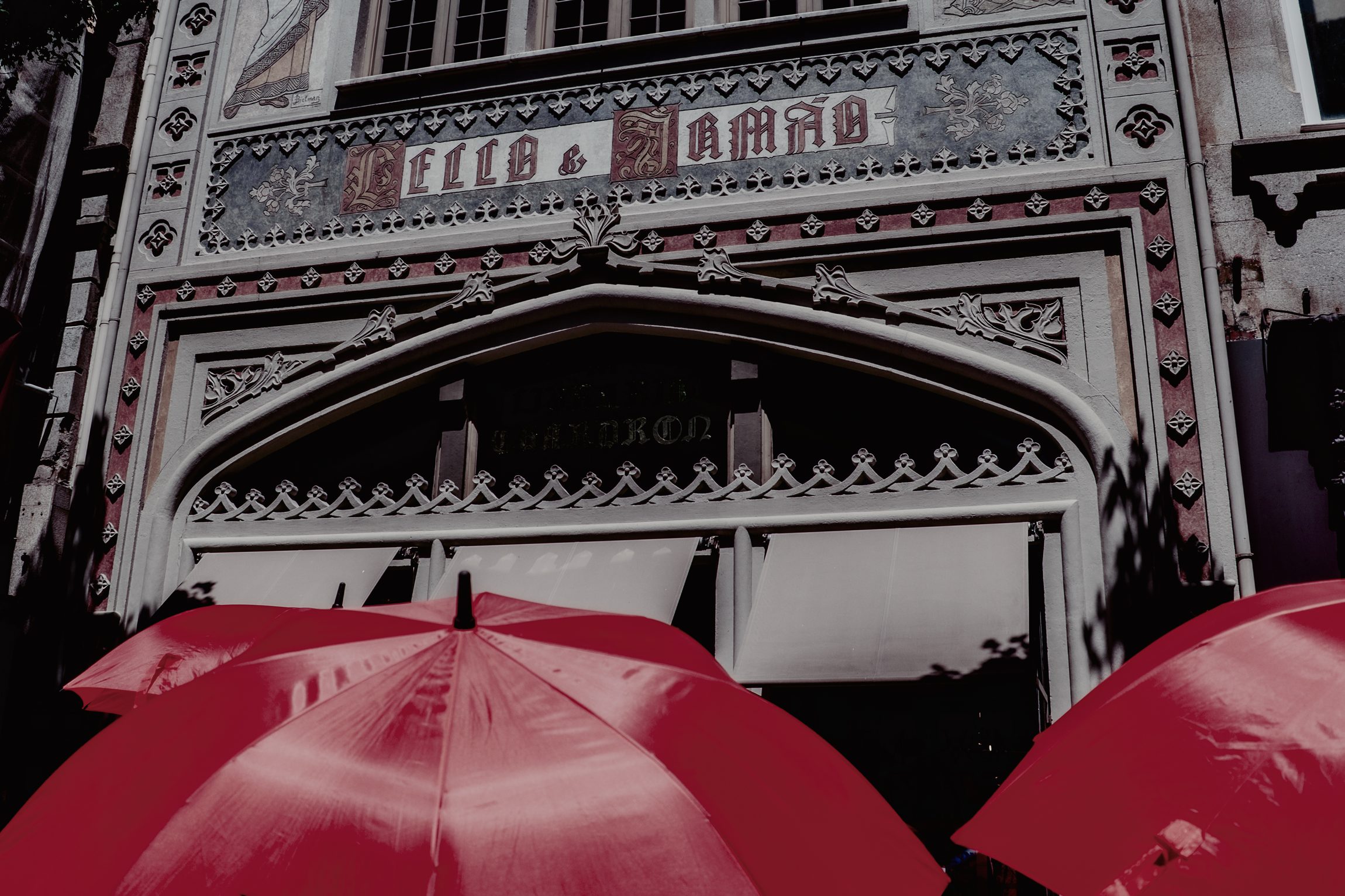 Fa&ccedil;ade orn&eacute;e d'un immeuble de Porto avec parasols rouges