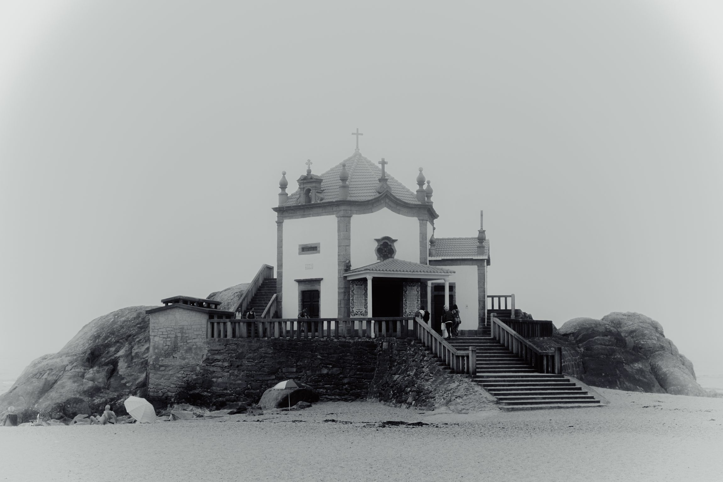 Chapelle sur un rocher au bord de la plage, noir et blanc