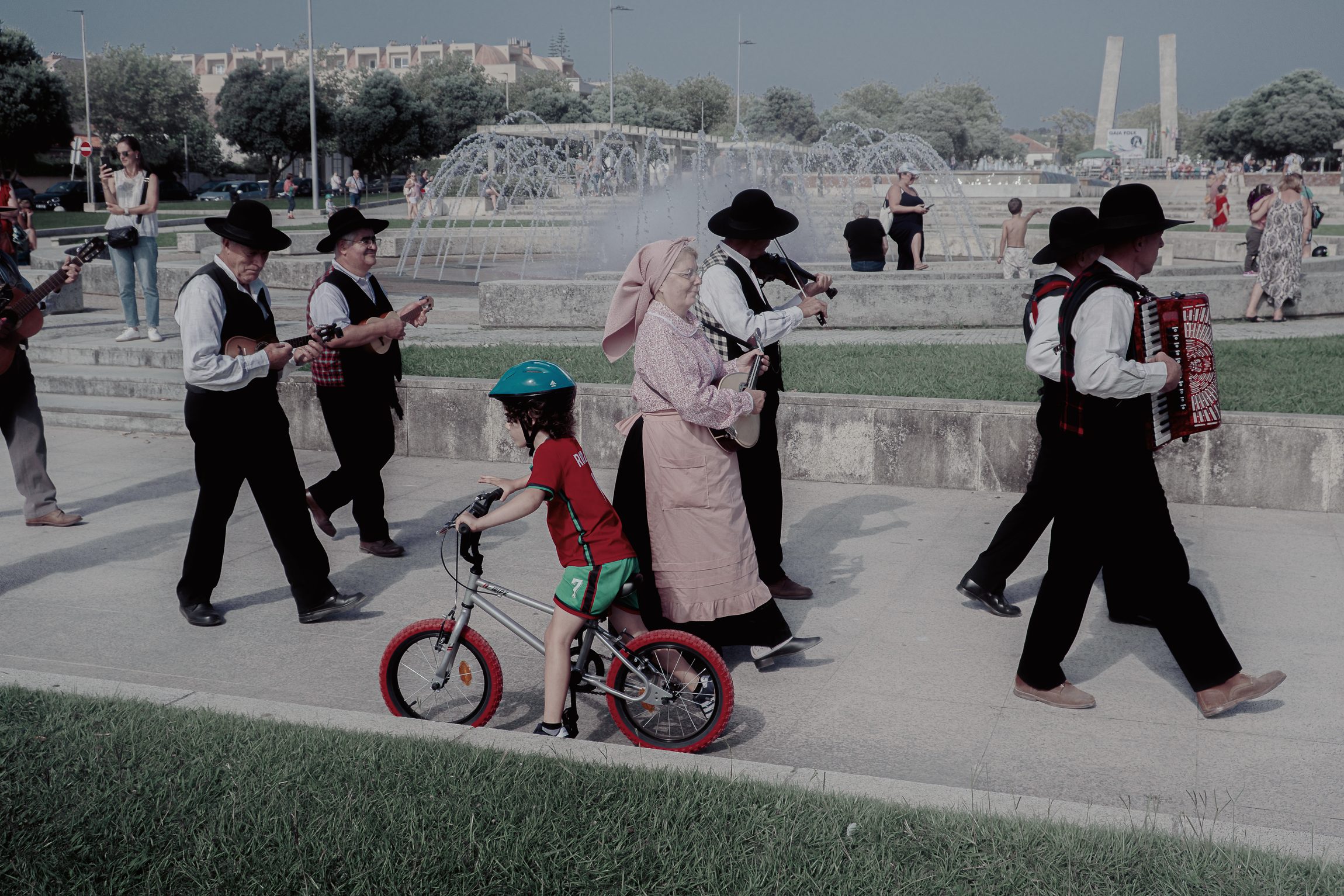 D&eacute;fil&eacute; de musiciens folkloriques, enfant &agrave; v&eacute;lo