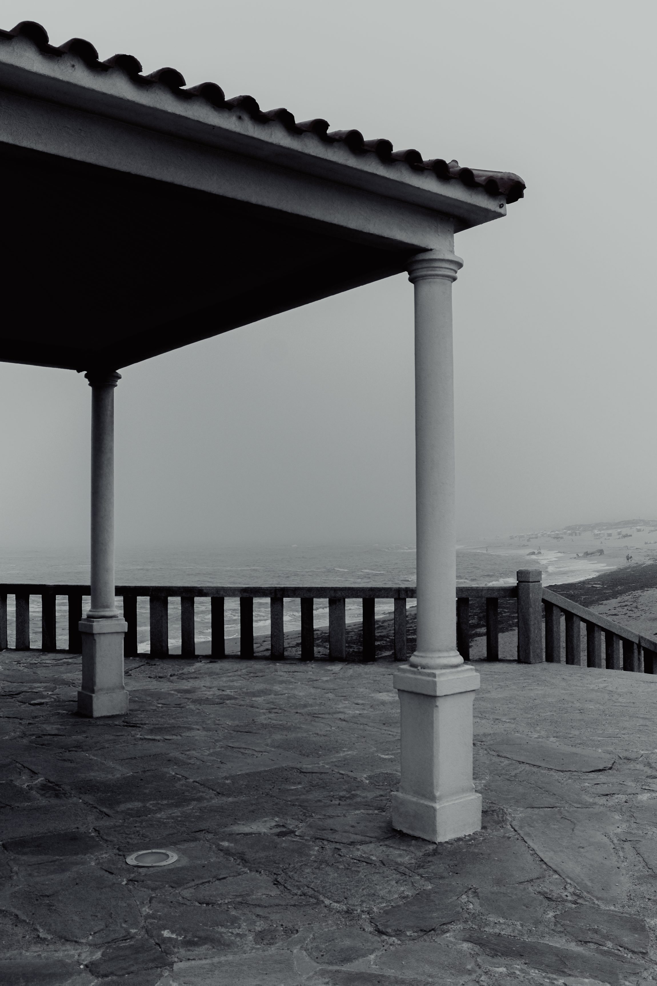 Colonnade et toiture en tuiles, vue sur l'oc&eacute;an, noir et blanc