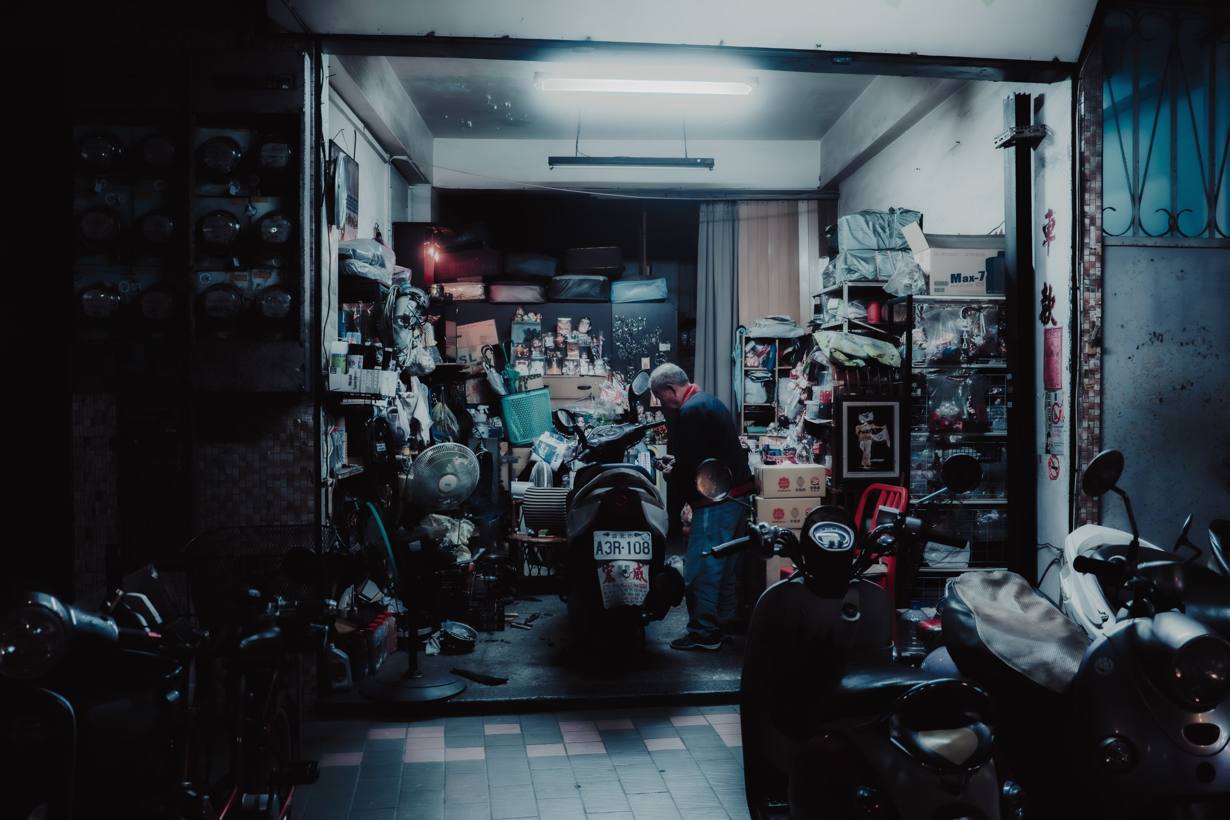 Garage de scooters encombr&eacute;, r&eacute;parateur au travail