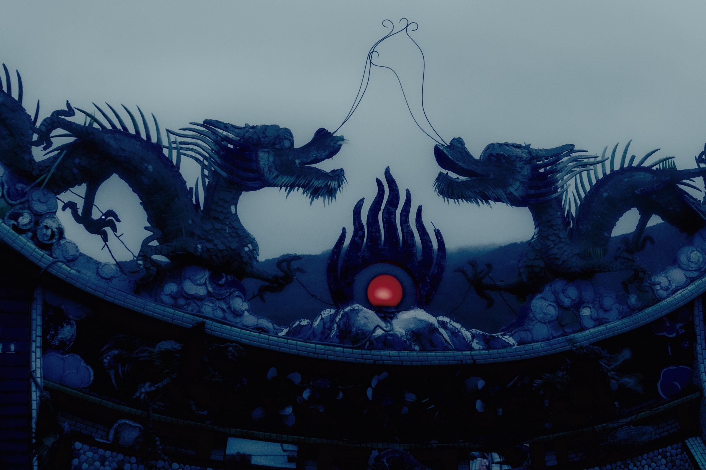 Toit de temple, dragons et perle rouge dans la brume